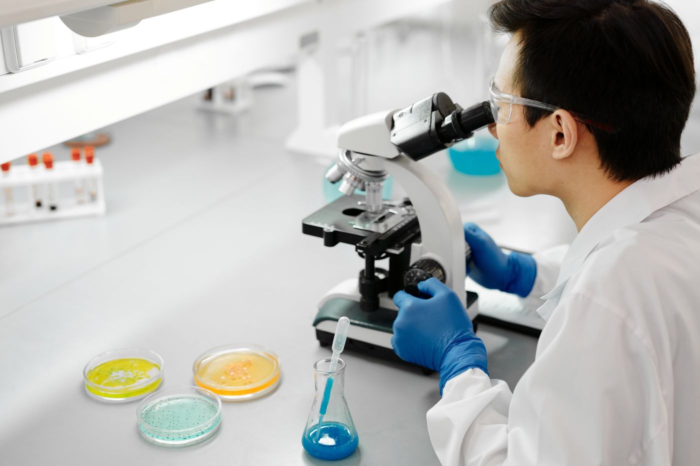Illustrative stock photograph of a scientist using a microscope